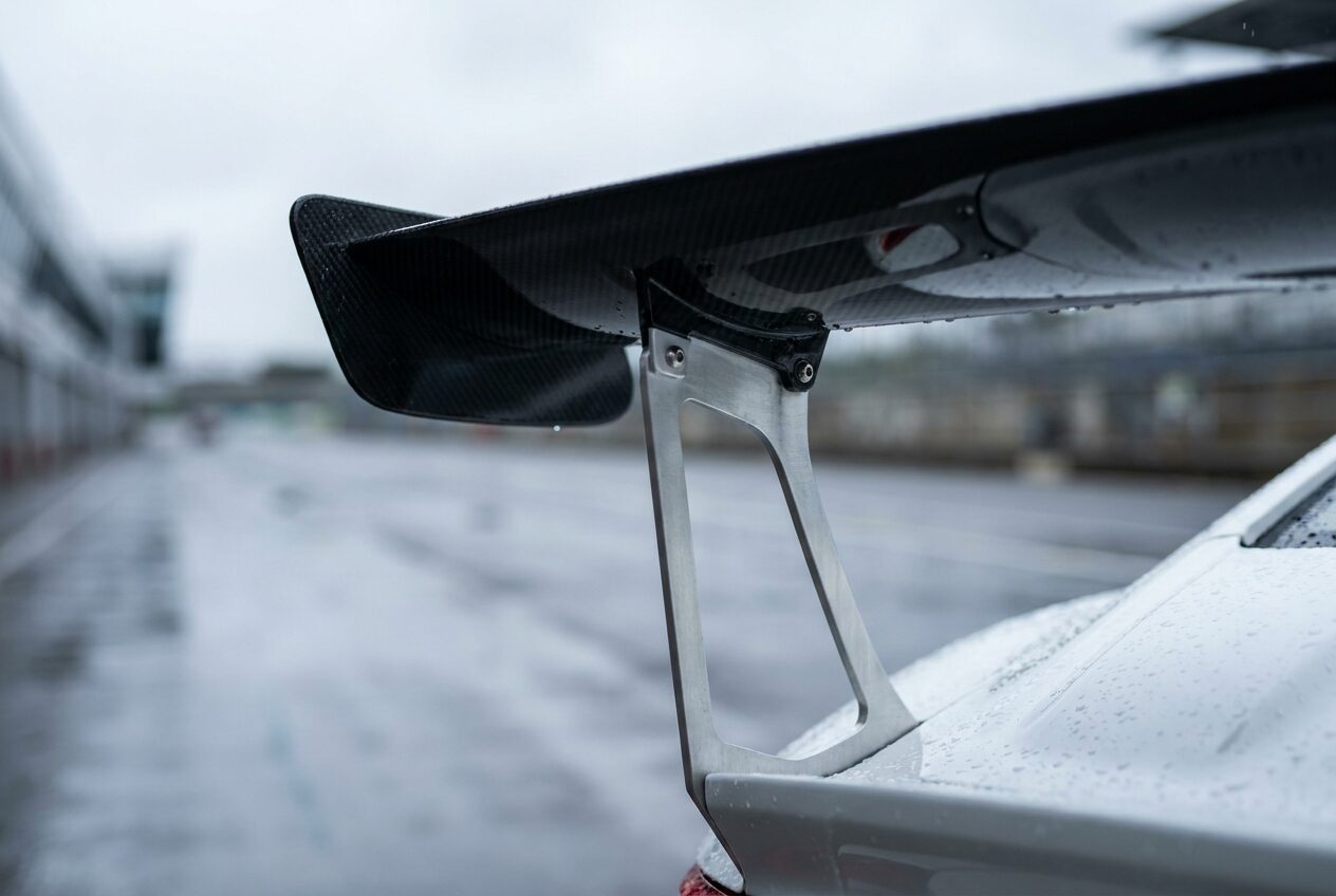 Tall black carbon fibre rear wing on swan neck mounts