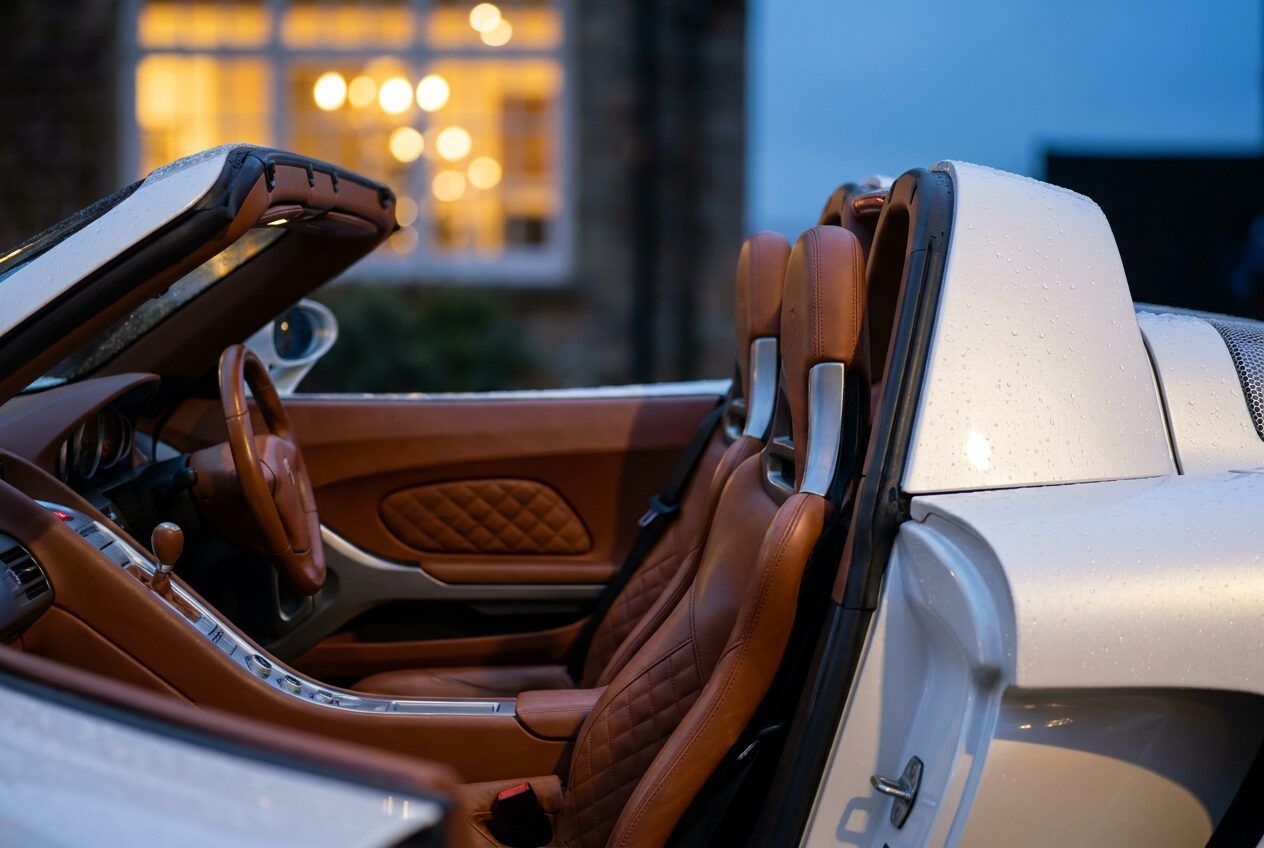 Open cockpit with tan quilted leather seats and the roof stowed