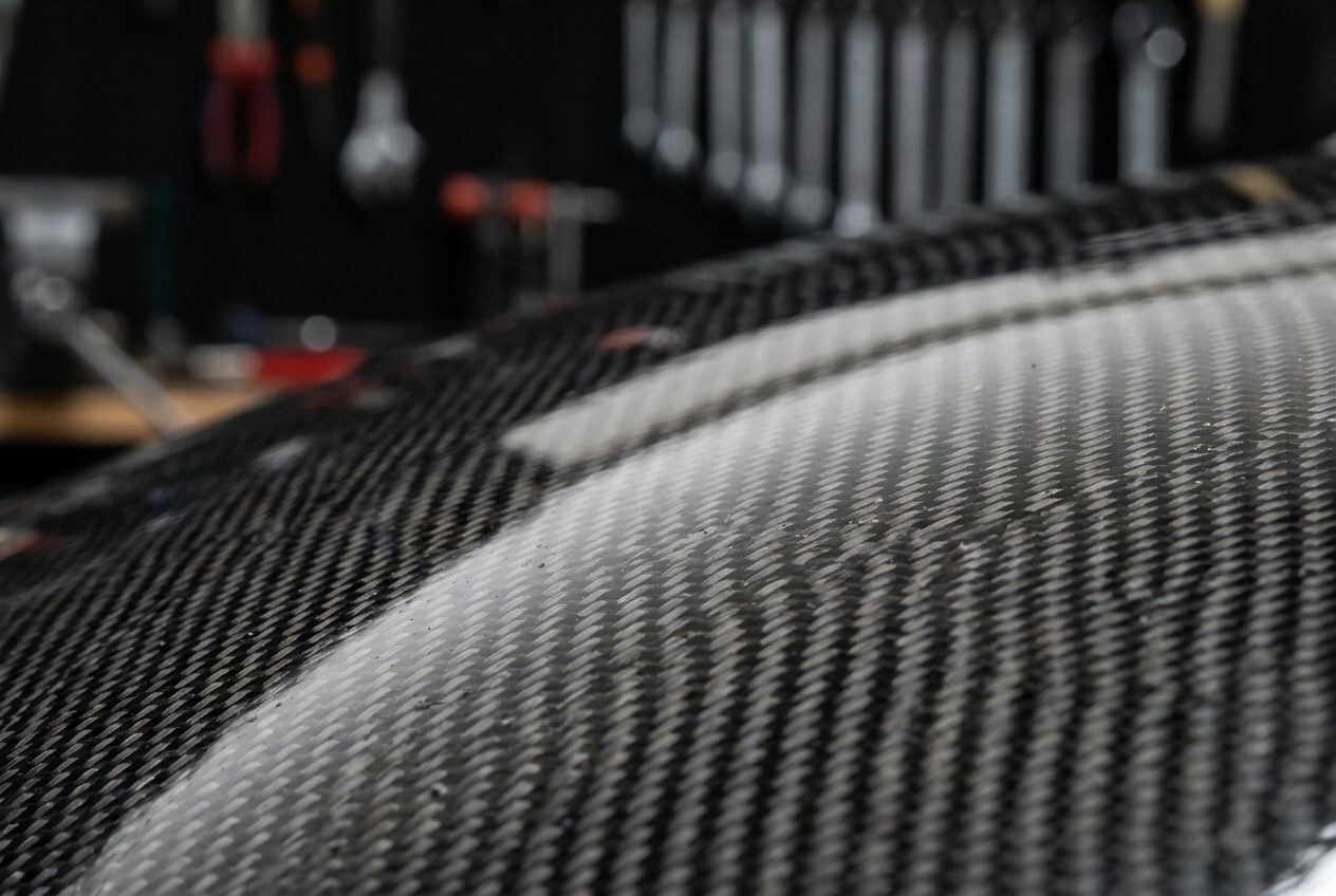 Macro view of exposed carbon fibre twill weave under gloss lacquer