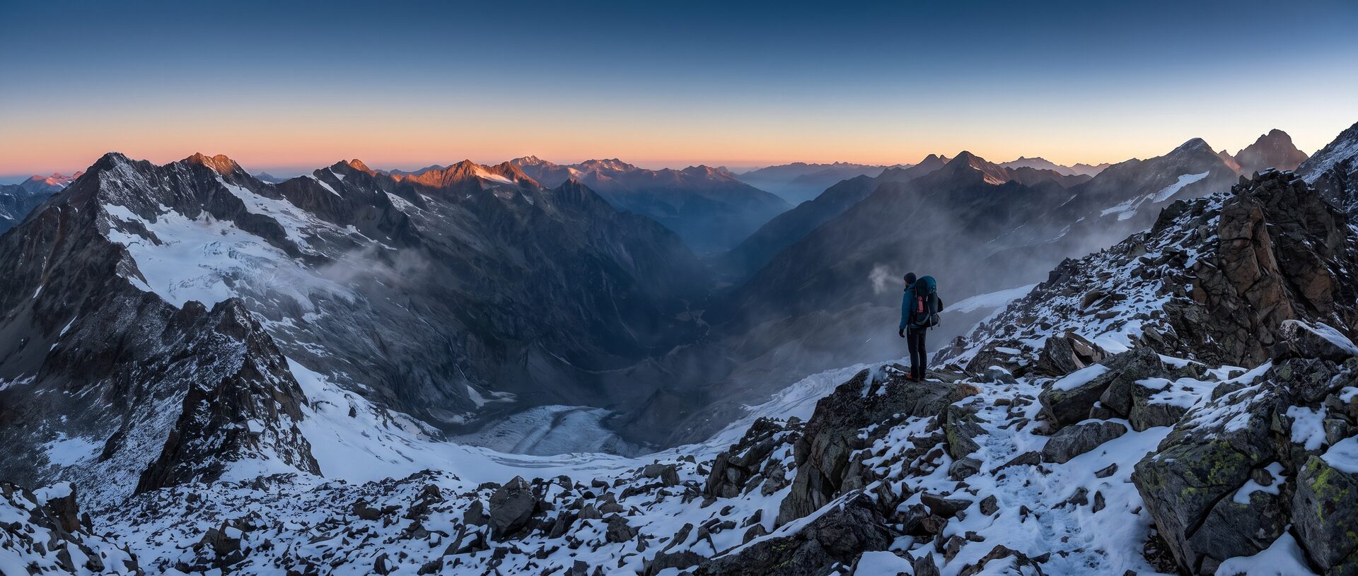 A lone hiker on a high mountain ridge at dawn, a vast valley far below in cold blue light